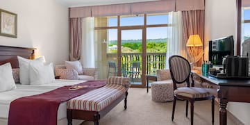 a room with a bed and a table and chairs