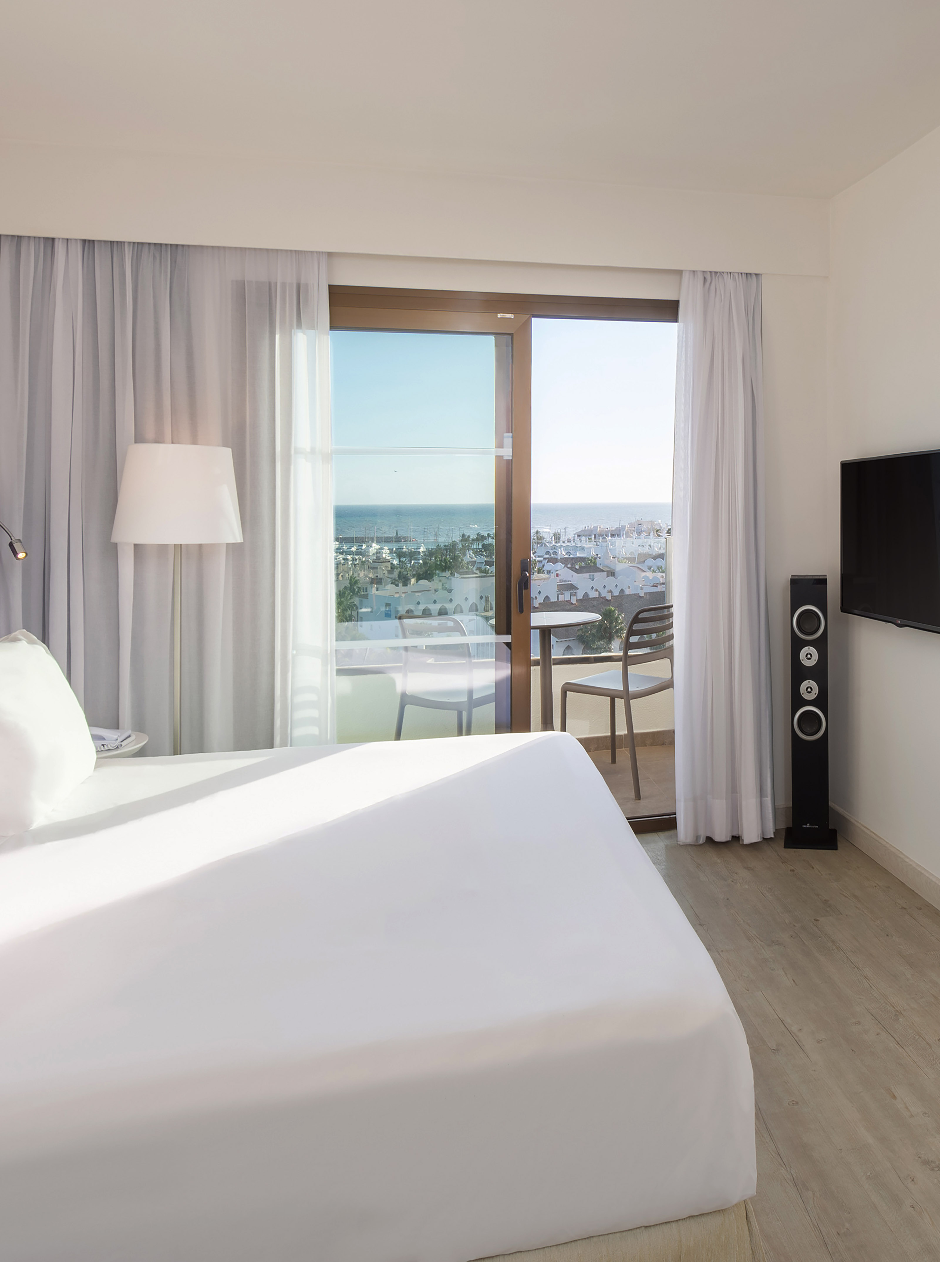 a bedroom with a large window and a television