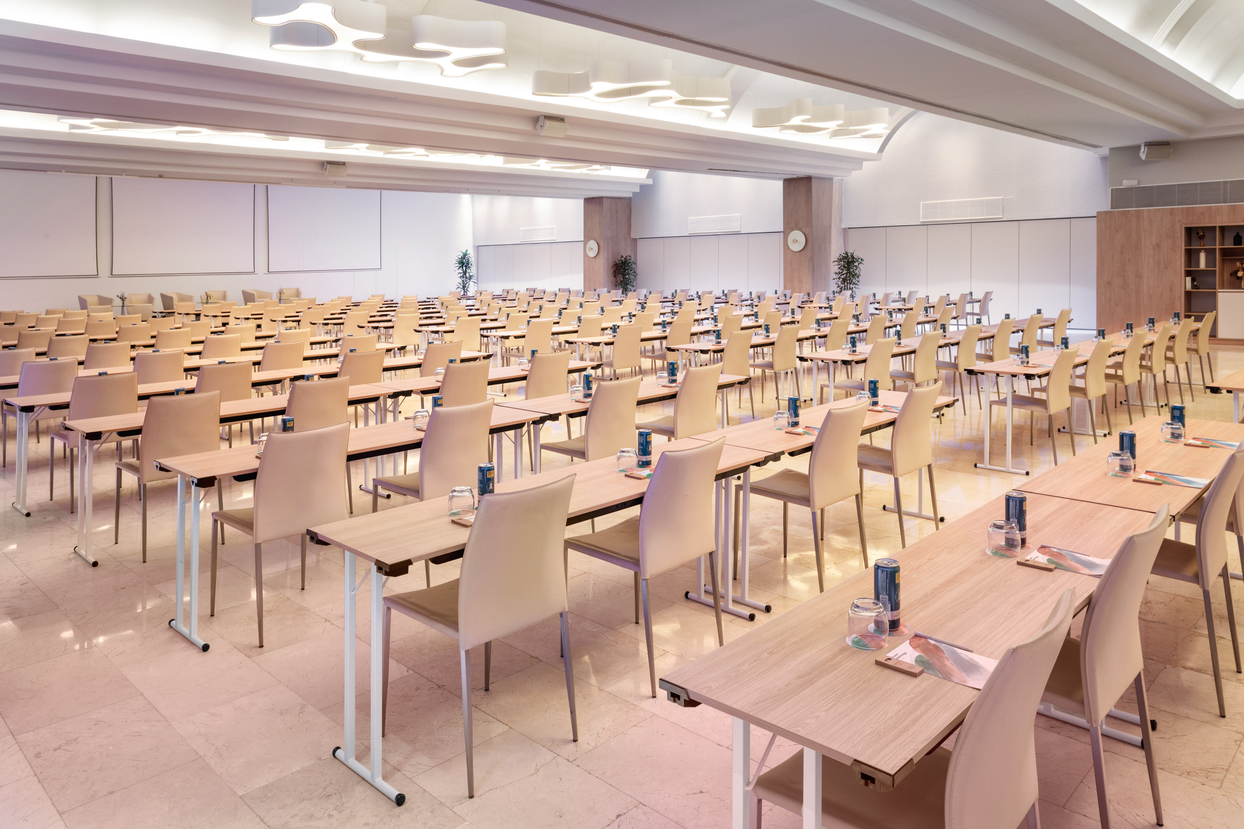 Empty spacious conference room setup with tables and chairs for corporate events.