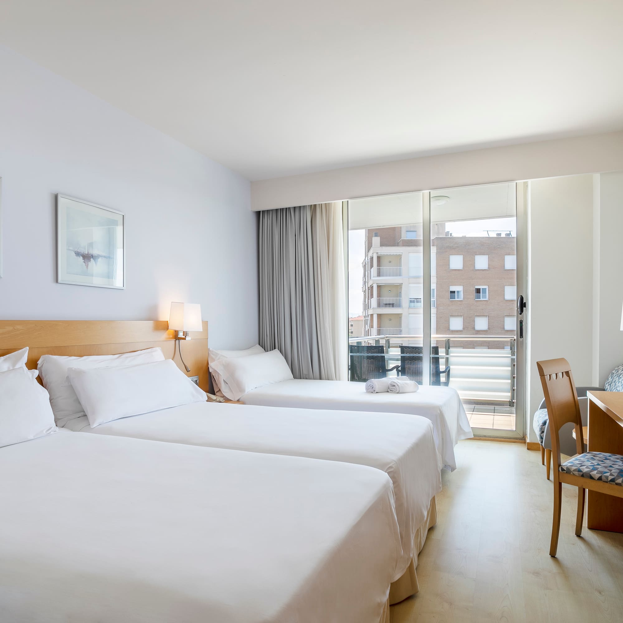 a room with two beds and a desk