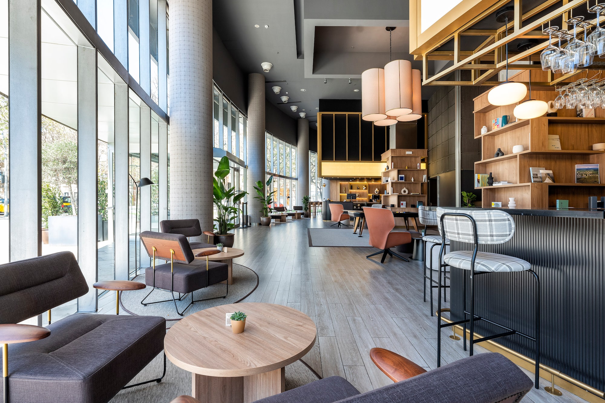 Spacious modern hotel lounge with bar, diverse seating, and large windows.