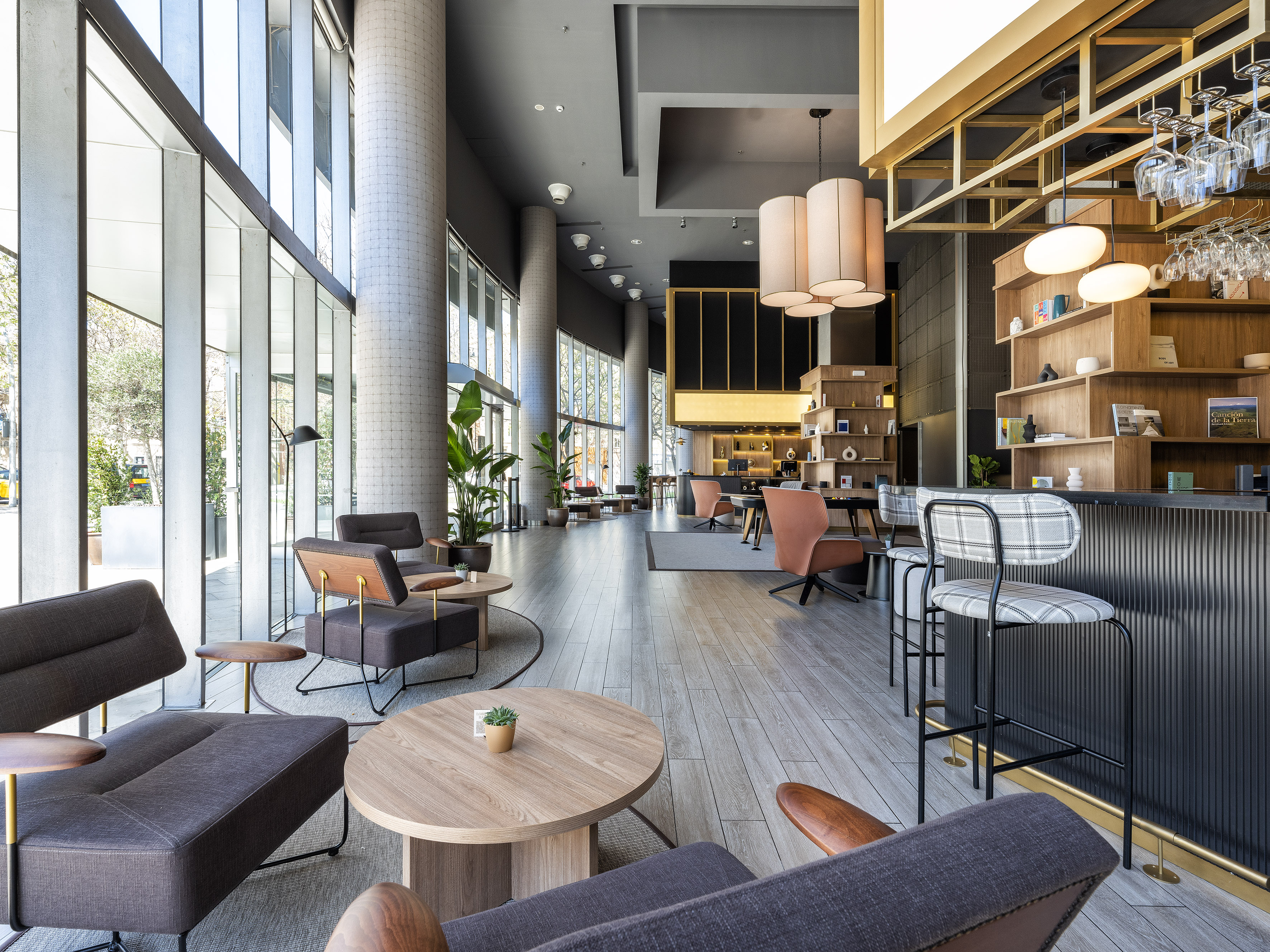 Spacious modern hotel lounge with bar, diverse seating, and large windows.