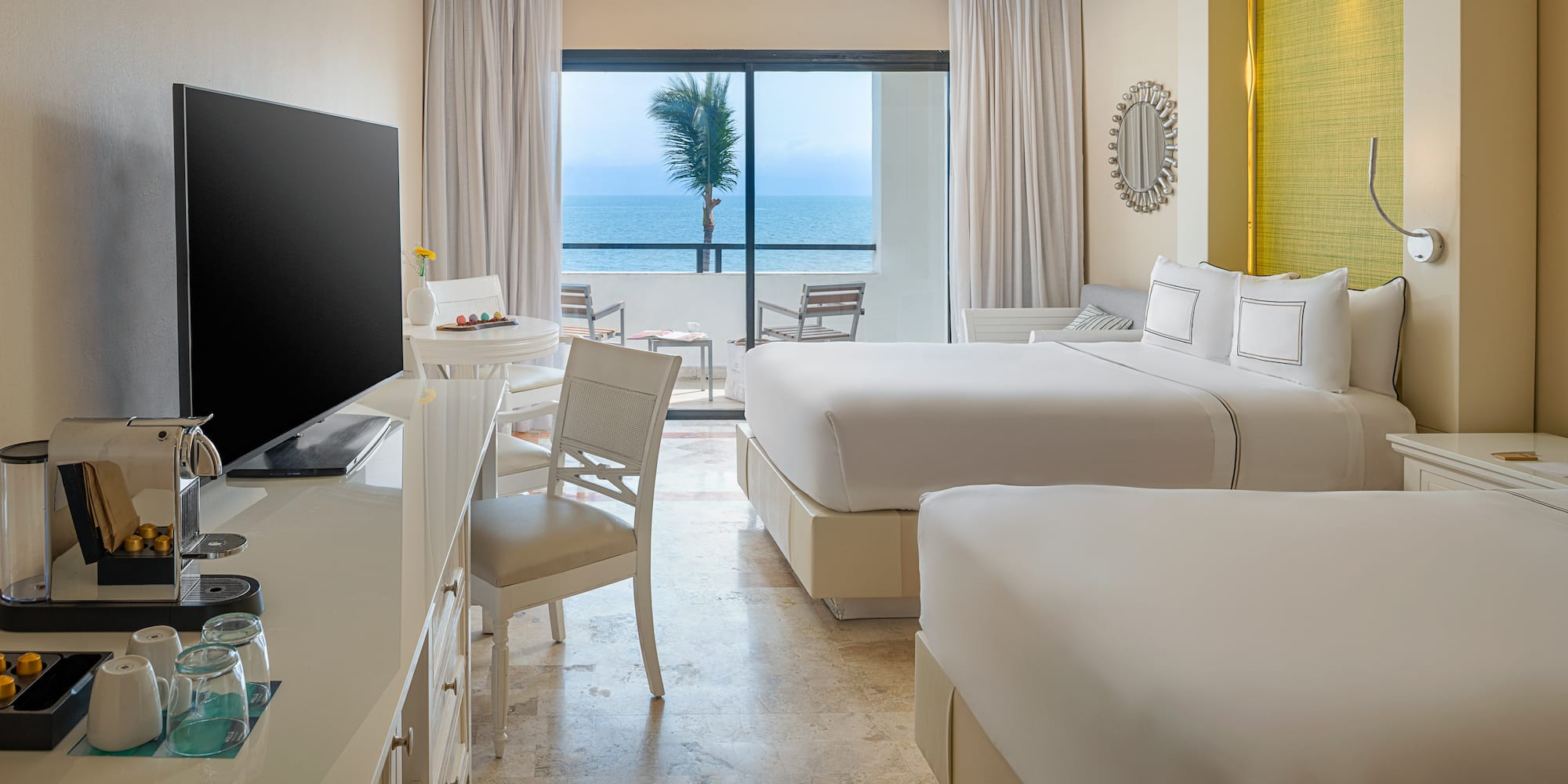 Tropical resort room with two beds, ocean view, and private balcony.