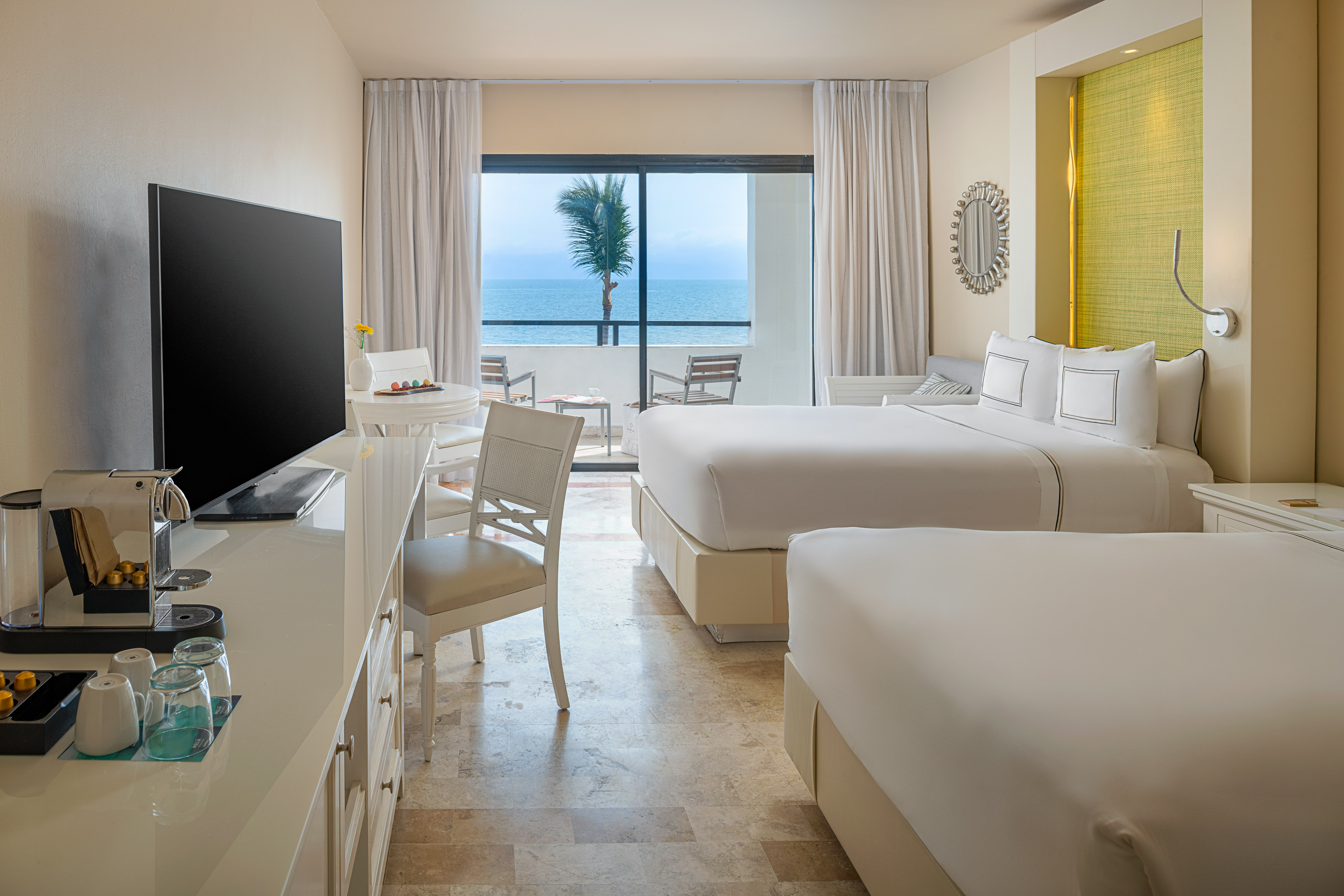 Tropical resort room with two beds, ocean view, and private balcony.