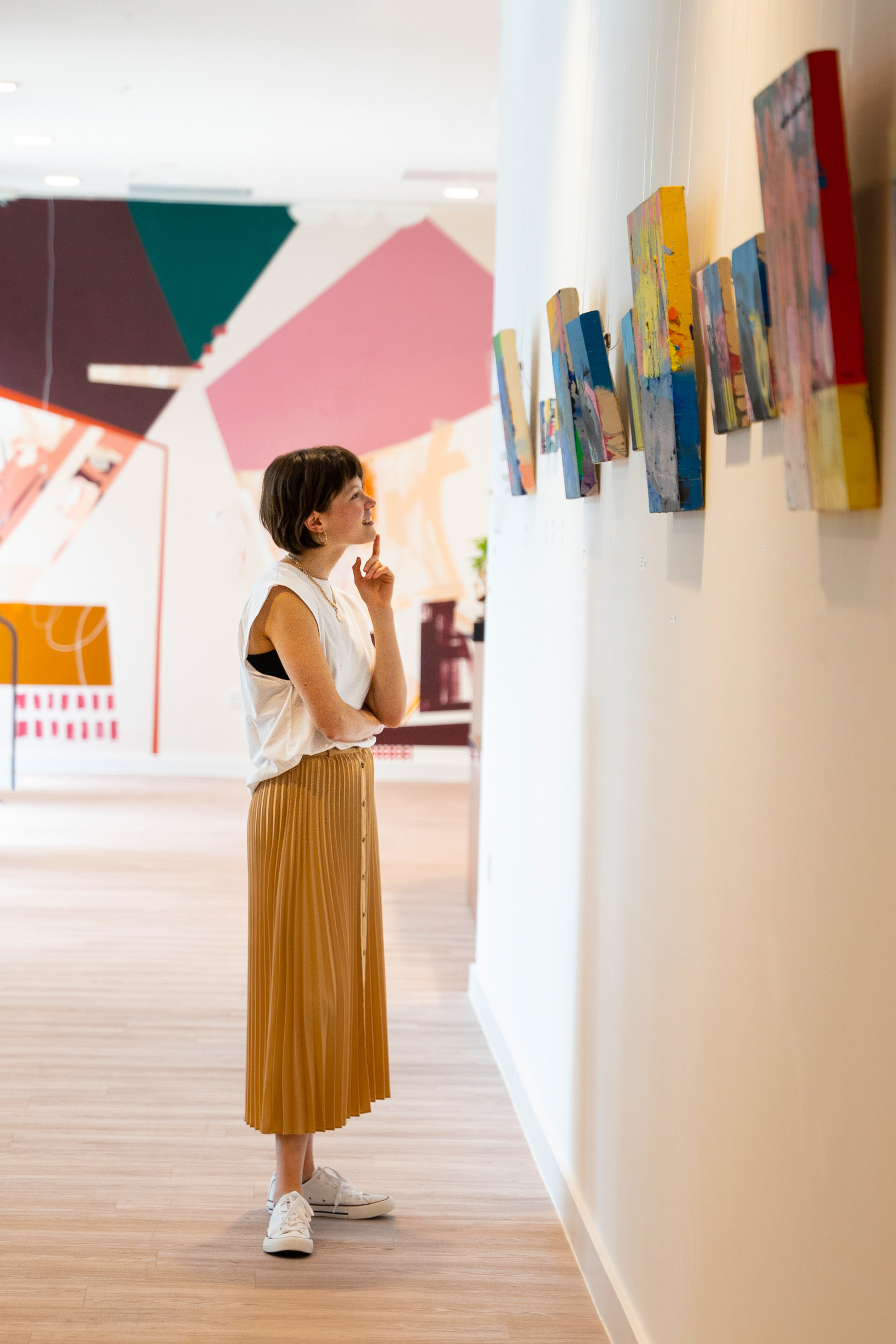 a woman looking at art on a wall