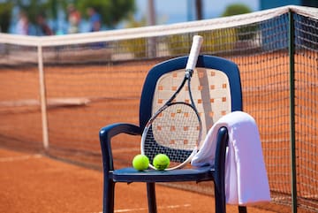 a tennis racket and balls on a chair