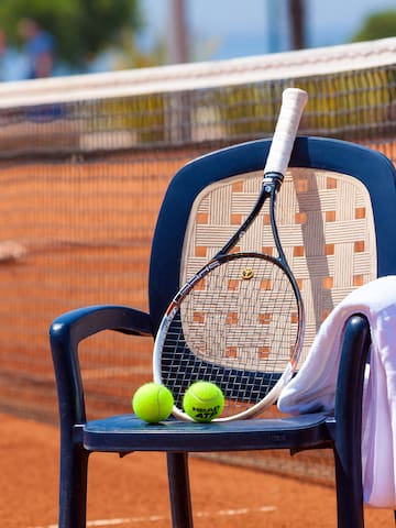 a tennis racket and balls on a chair
