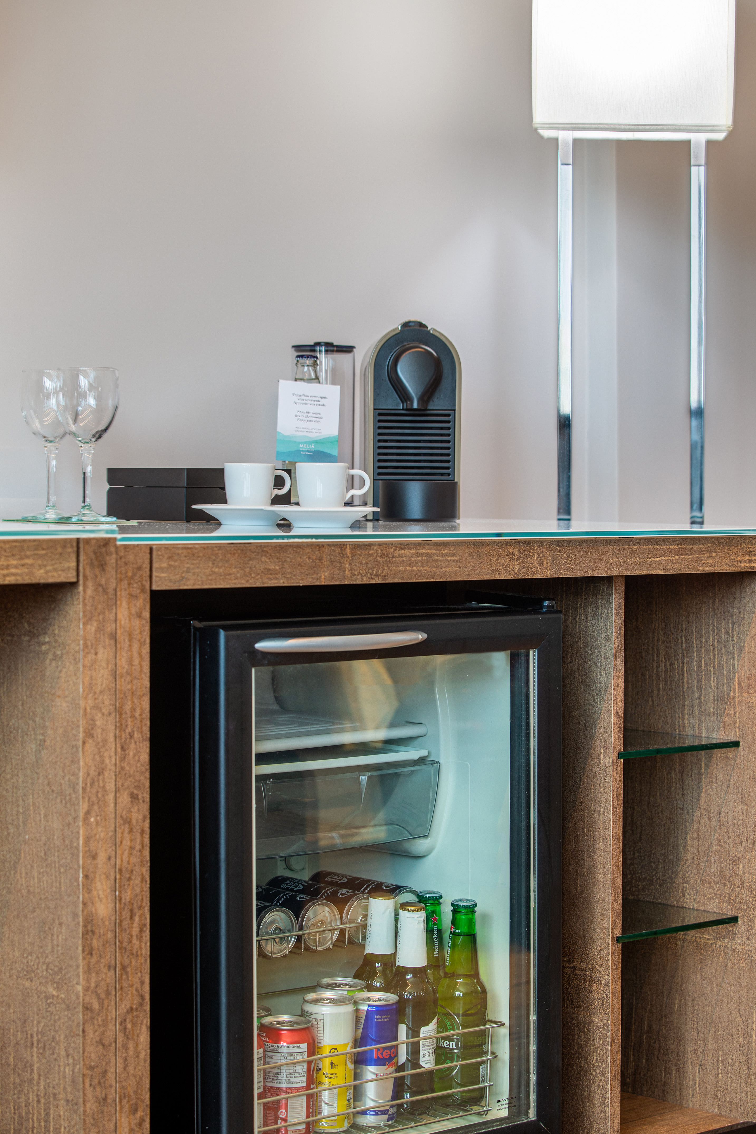 a mini fridge with drinks and cups on top of it