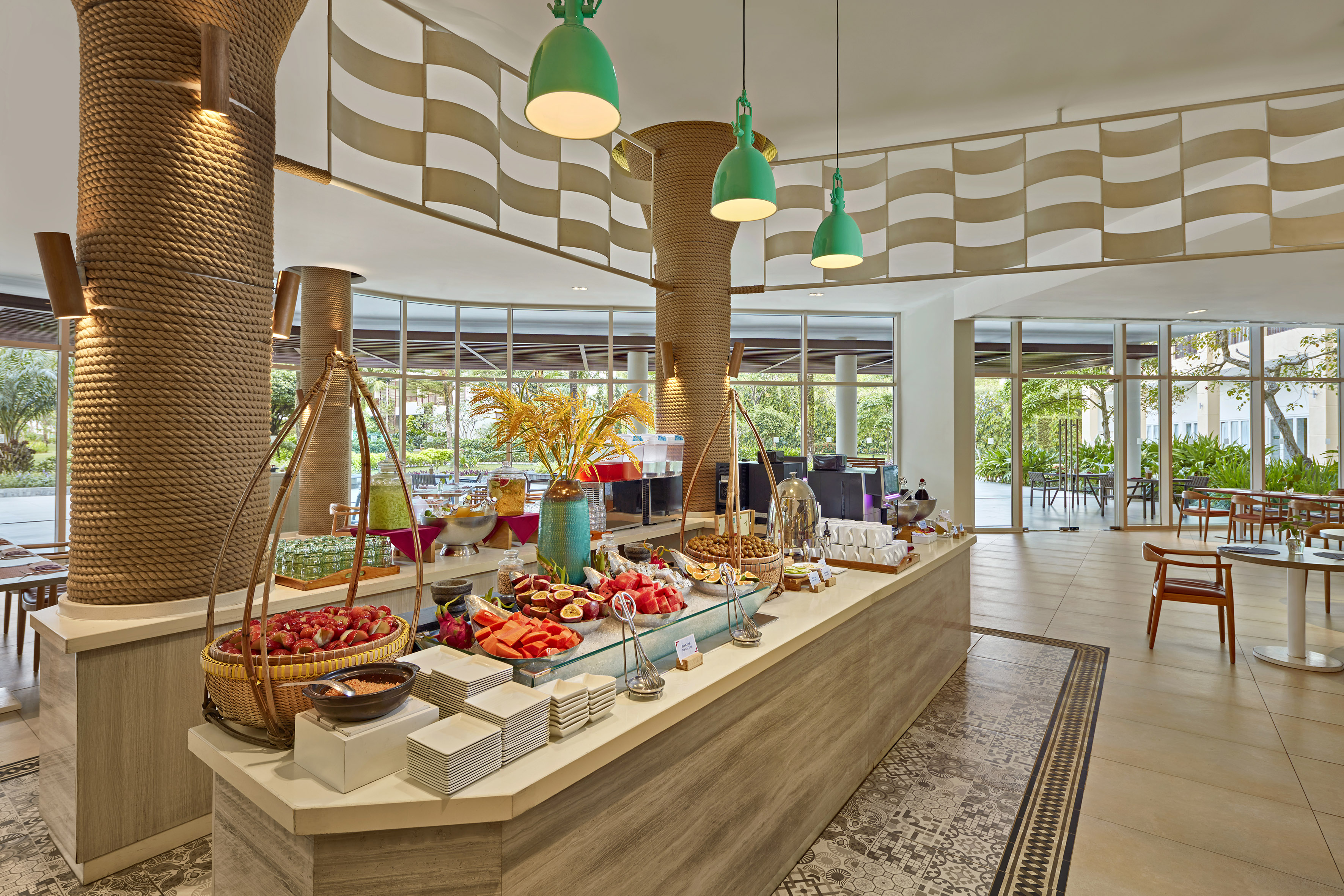 Hotel breakfast buffet with fresh tropical fruits, juices, and modern resort decor.
