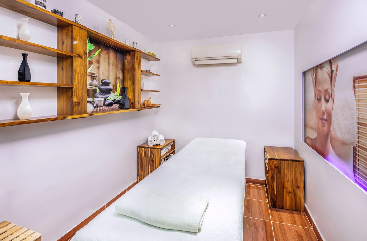 a massage room with a bed and shelves