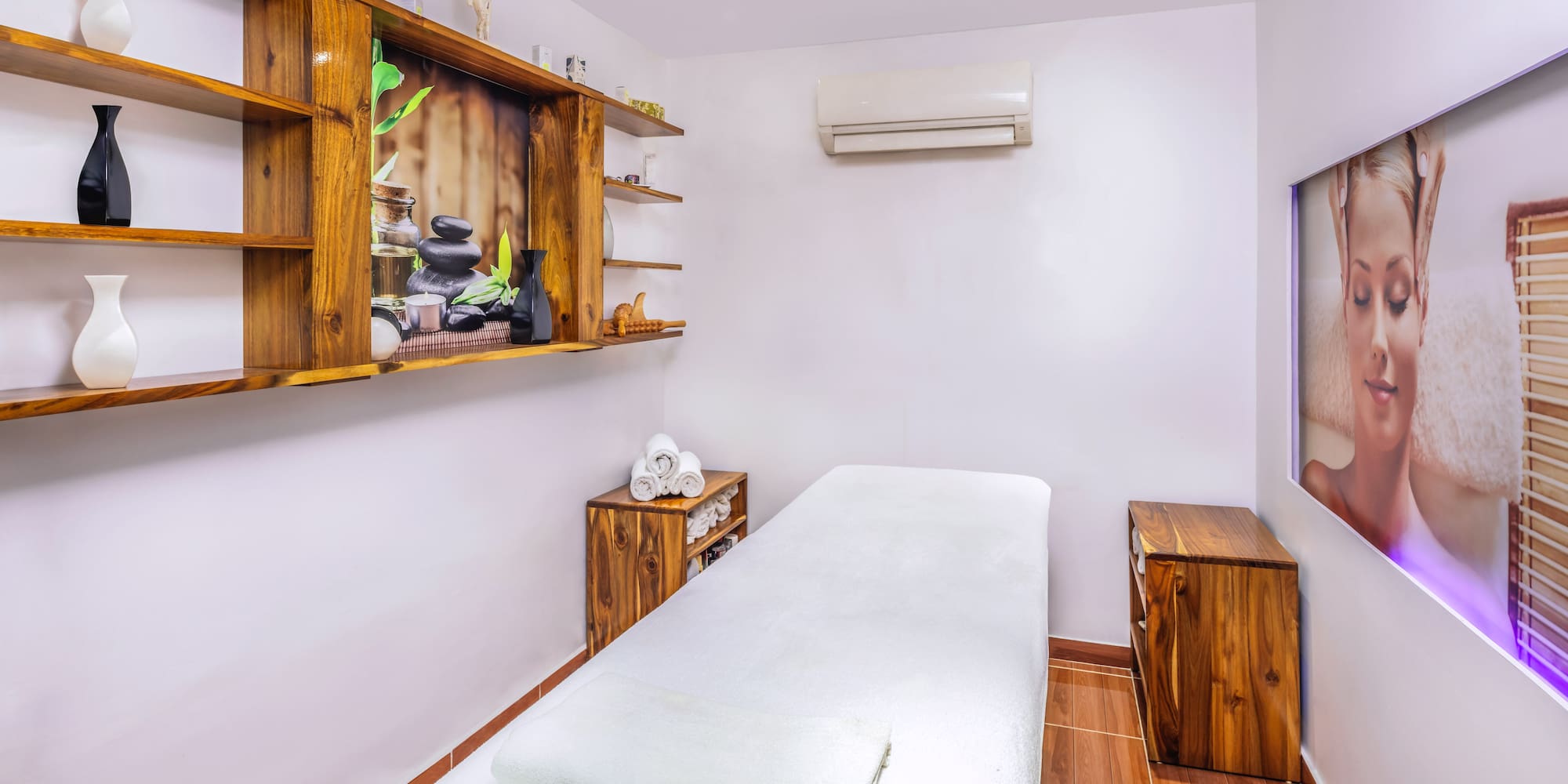 a massage room with a bed and shelves