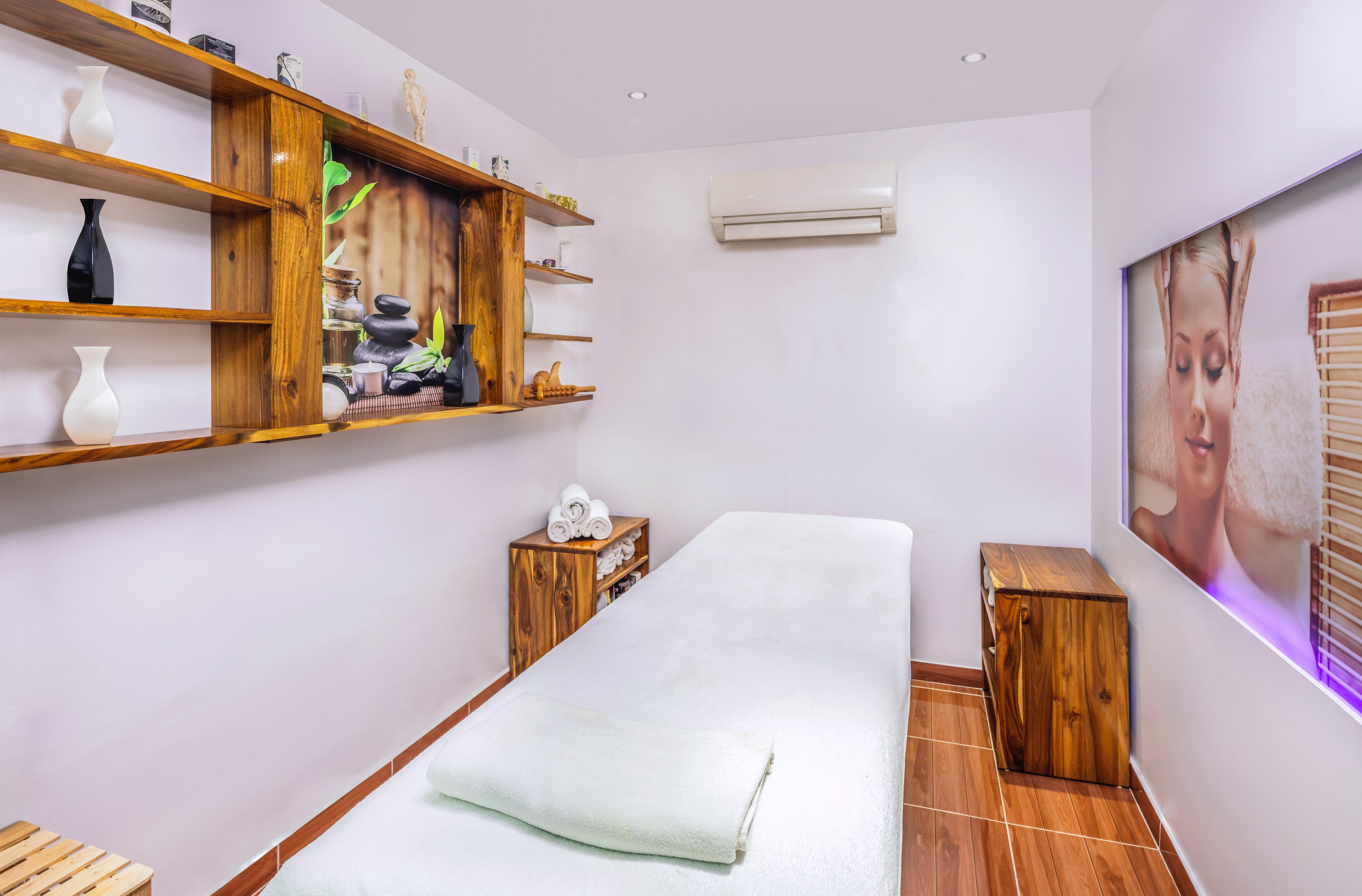 a massage room with a bed and shelves