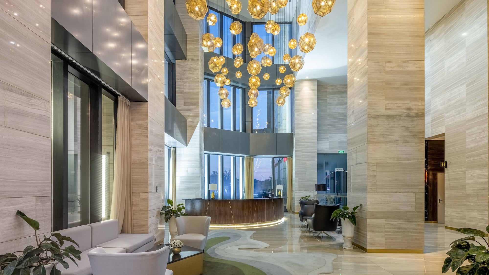 a lobby with a large chandelier and a reception desk