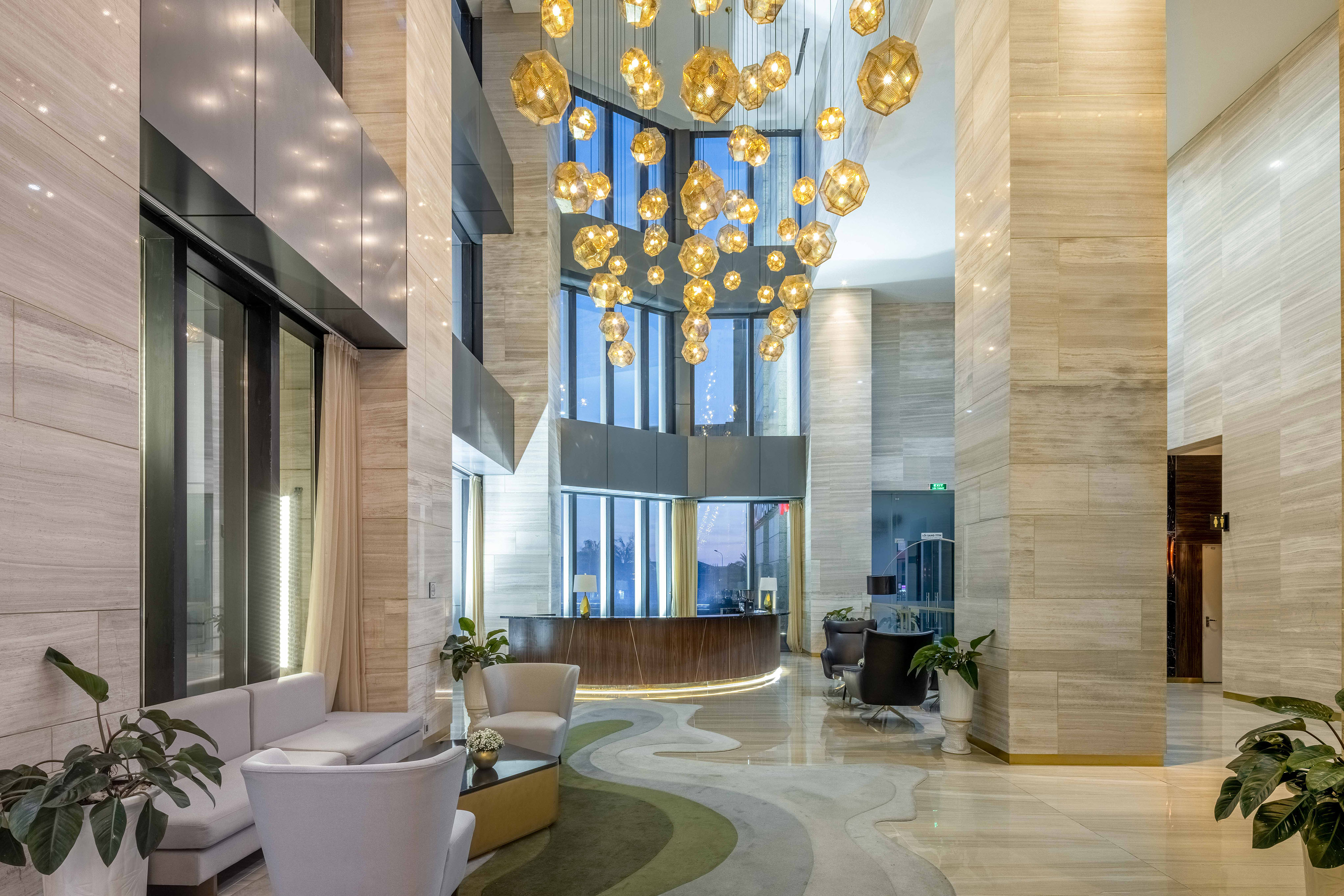 a lobby with a large chandelier and a reception desk