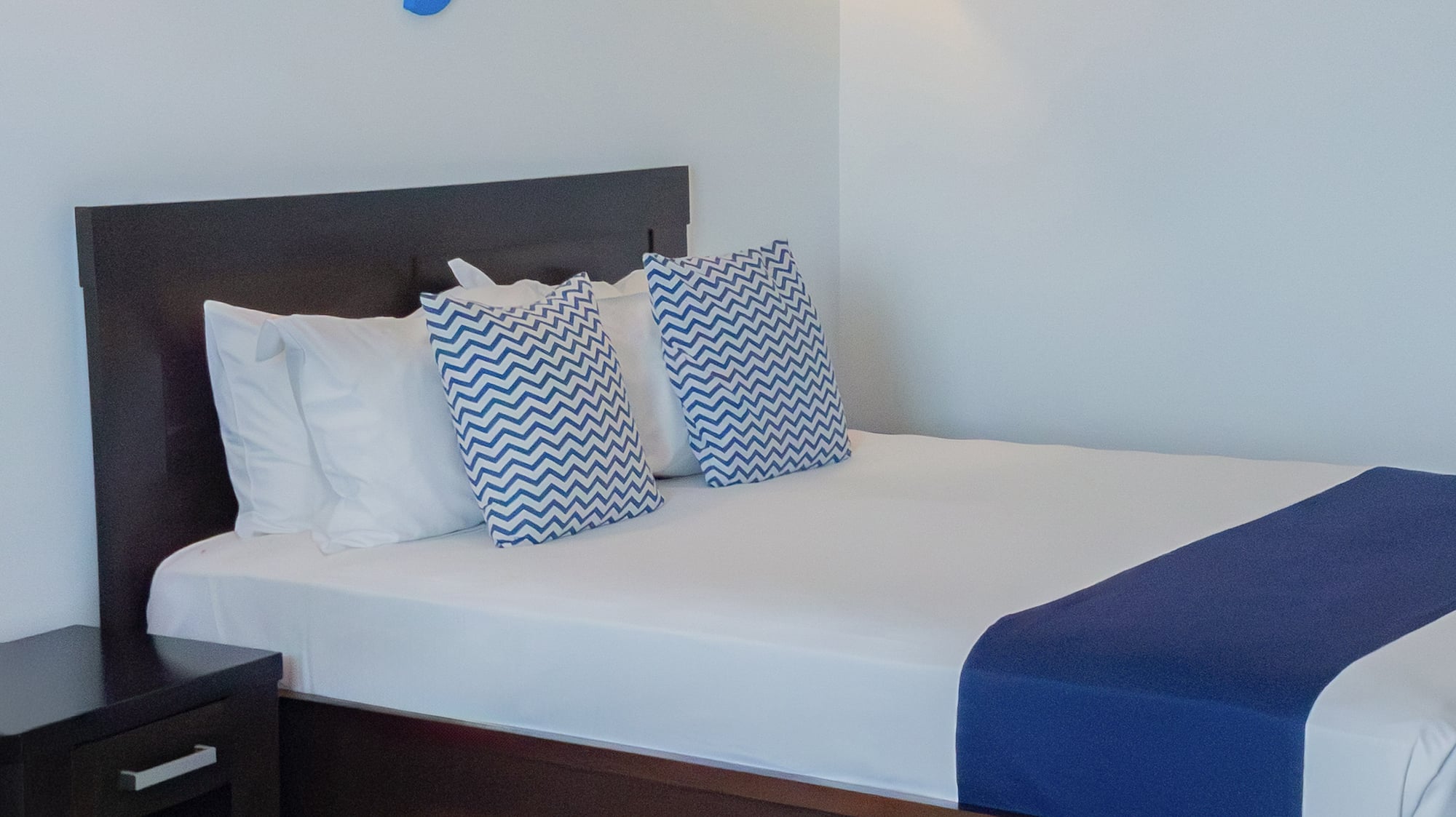 a bed with pillows and a nightstand in a room with fish decorations