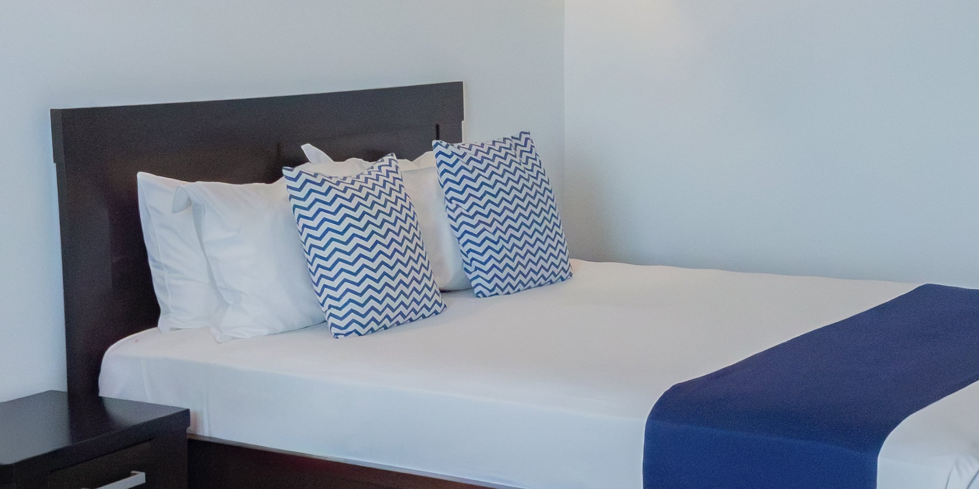 a bed with pillows and a nightstand in a room with fish decorations