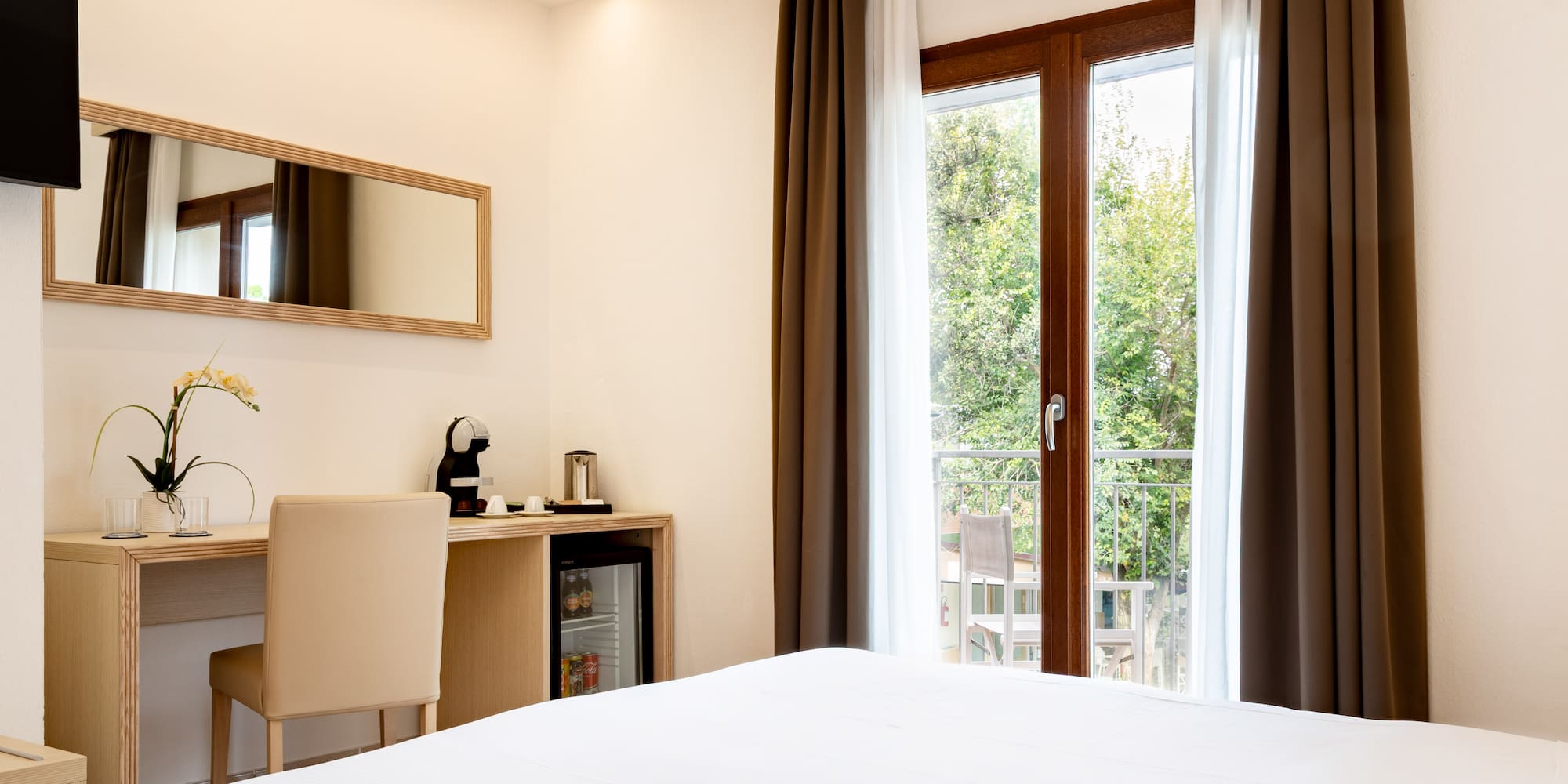 a room with a bed and a desk and a mirror