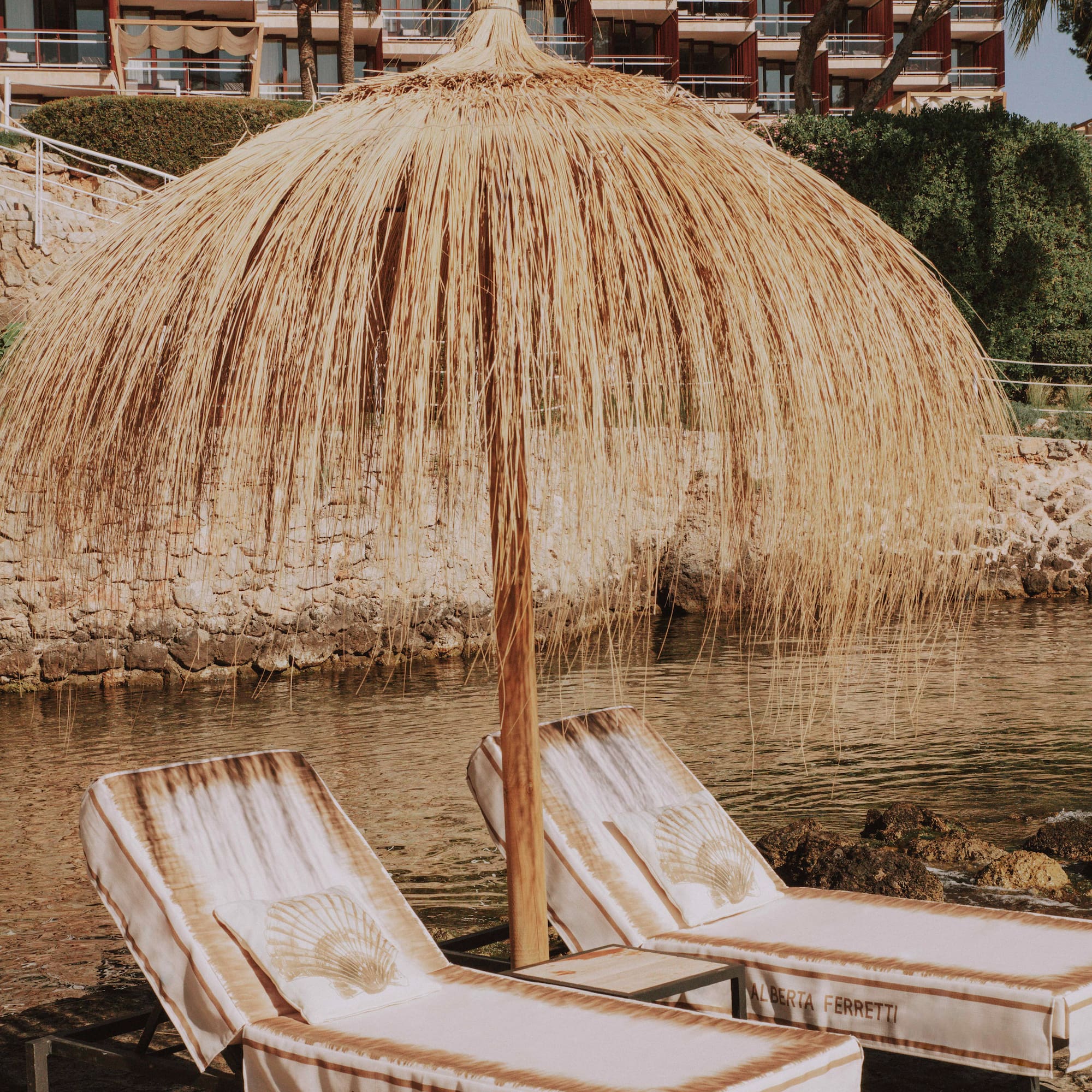 two chairs and umbrella on a body of water