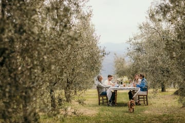 a group of people sitting at a table in a field