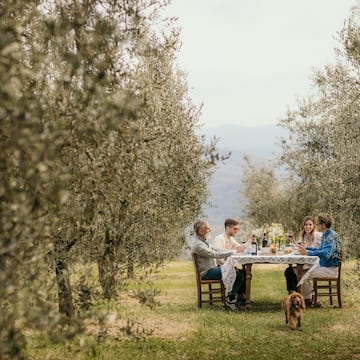 a group of people sitting at a table in a field