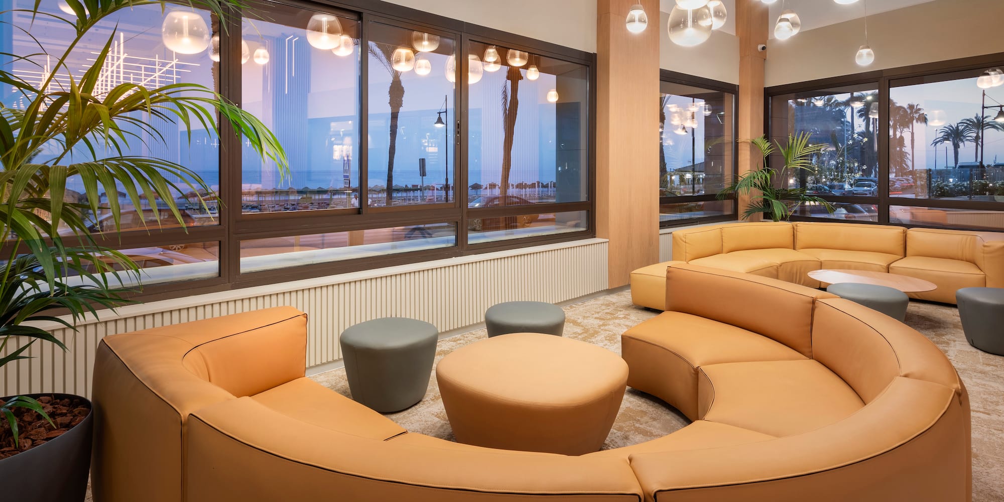 a room with a large round couch and tables