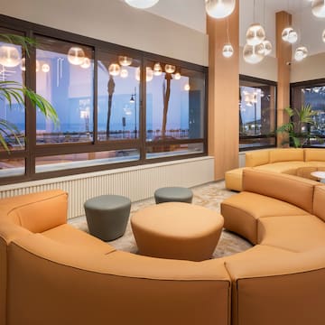 a room with a large round couch and tables