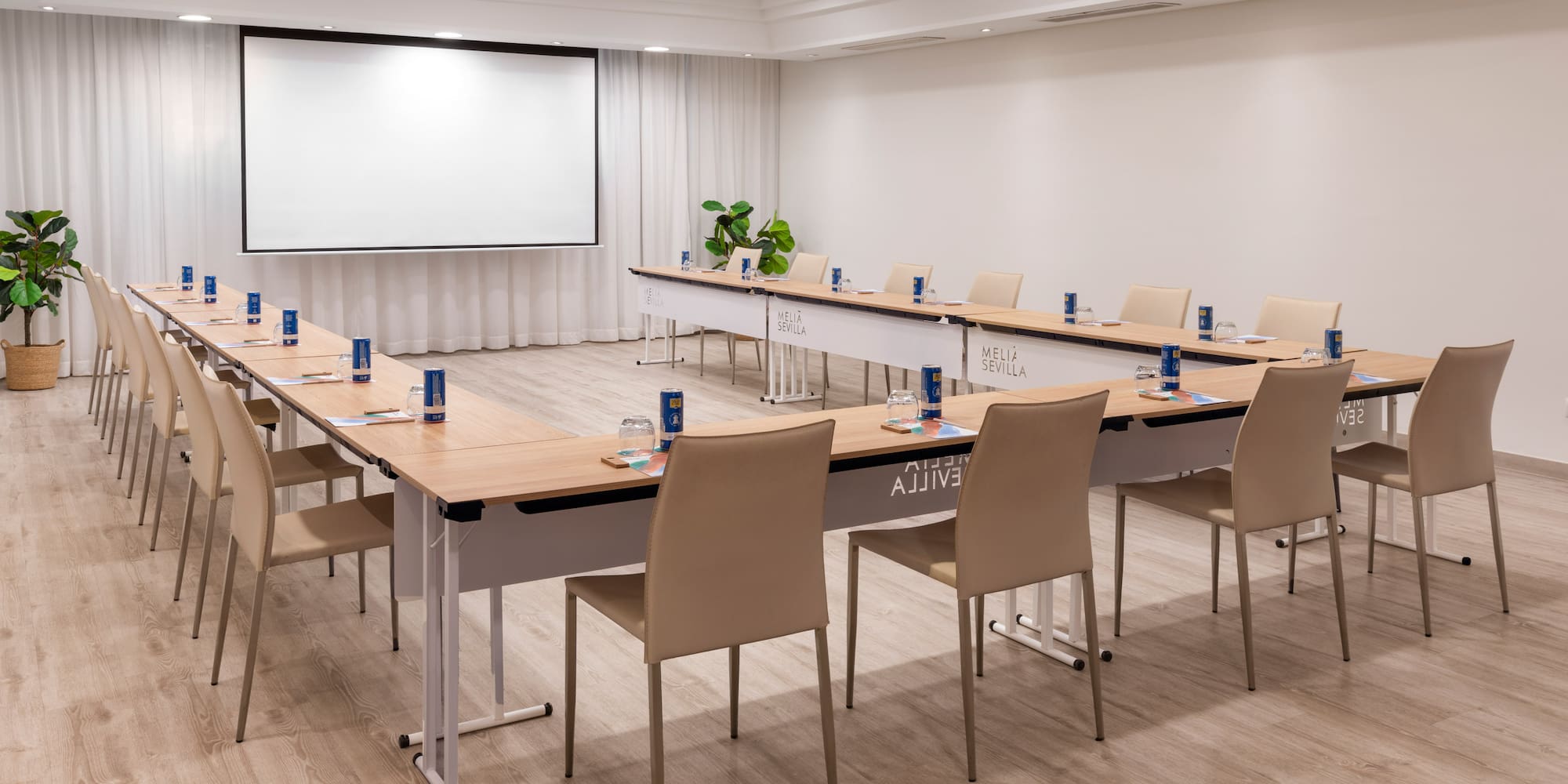 a room with a large screen and tables