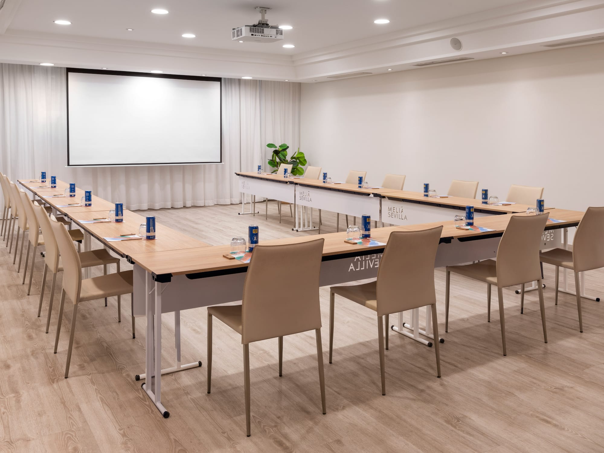 a room with a large screen and tables