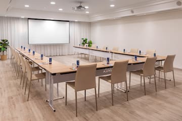 a room with a large screen and tables