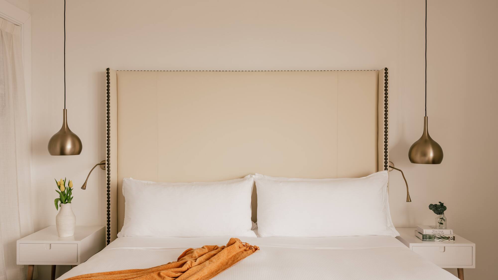 a bed with a blanket and lamps