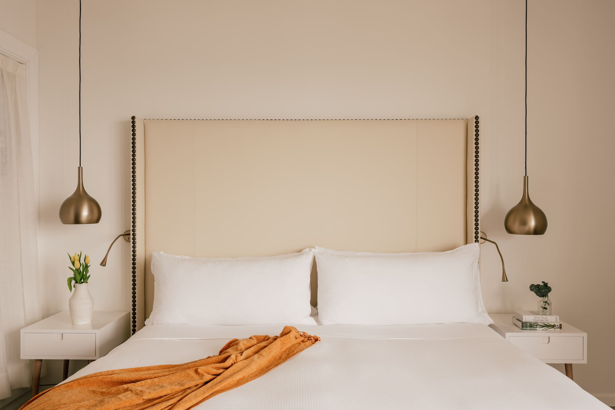 a bed with a blanket and lamps