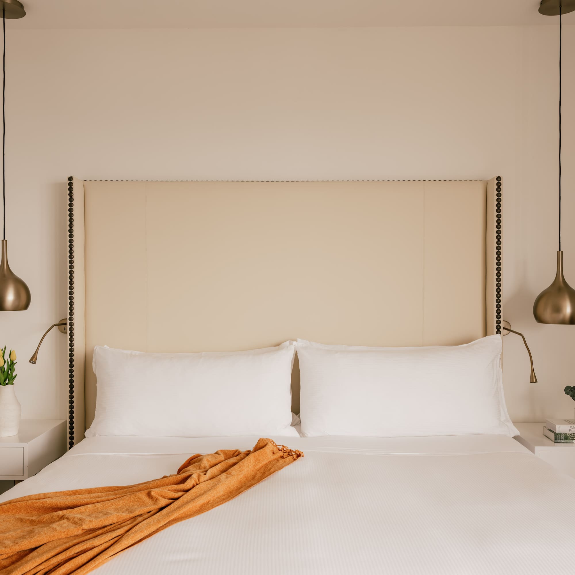 a bed with a blanket and lamps