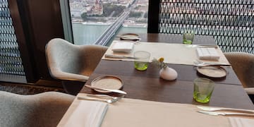 a table set for a dinner with a view of a city and a river