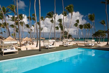 a pool with palm trees and a beach