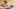 Neutral-toned modern bedroom with large bed, woven art, and sofa.