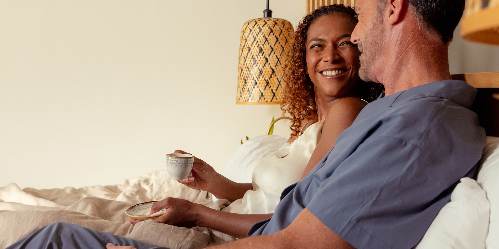 a man and woman sitting on a bed