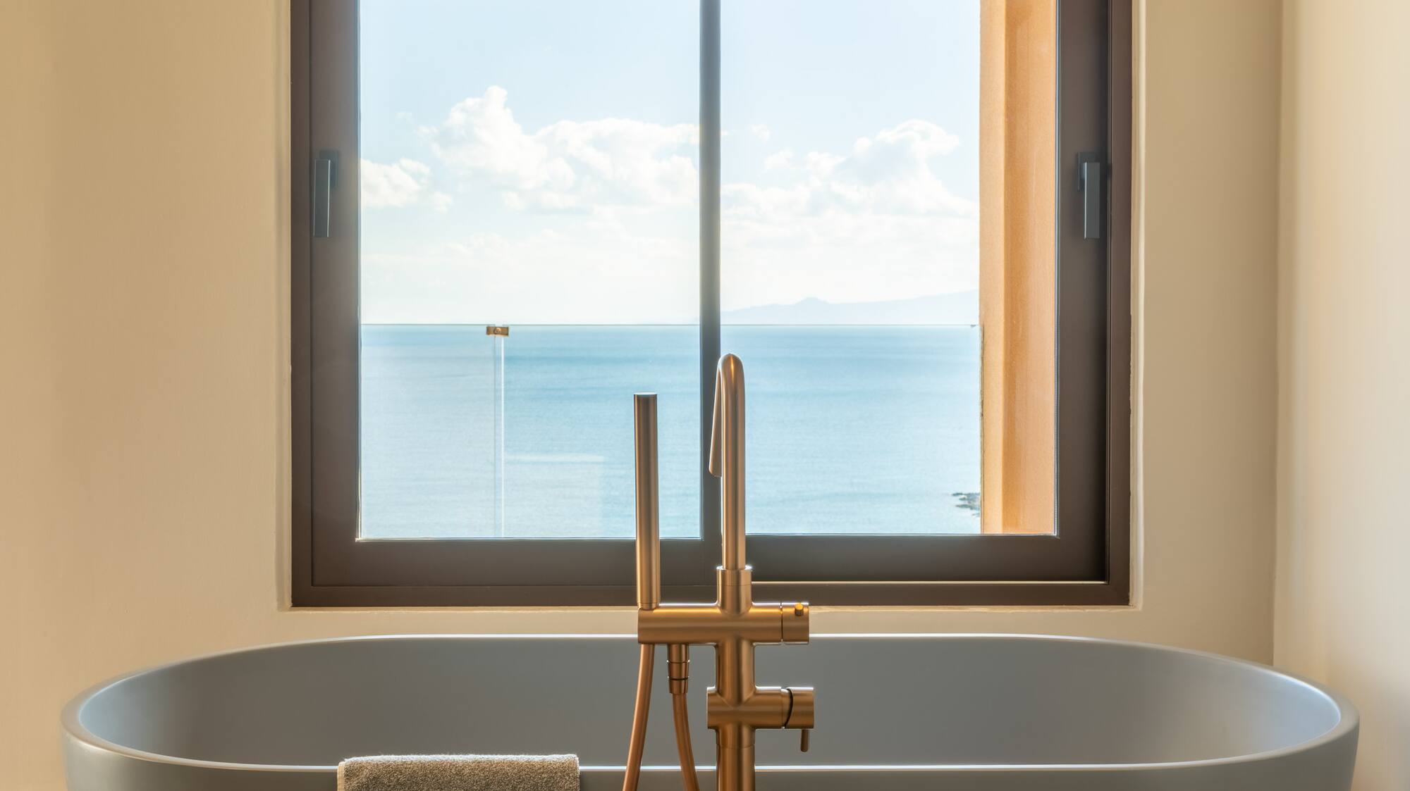 a bathtub with a window overlooking the ocean