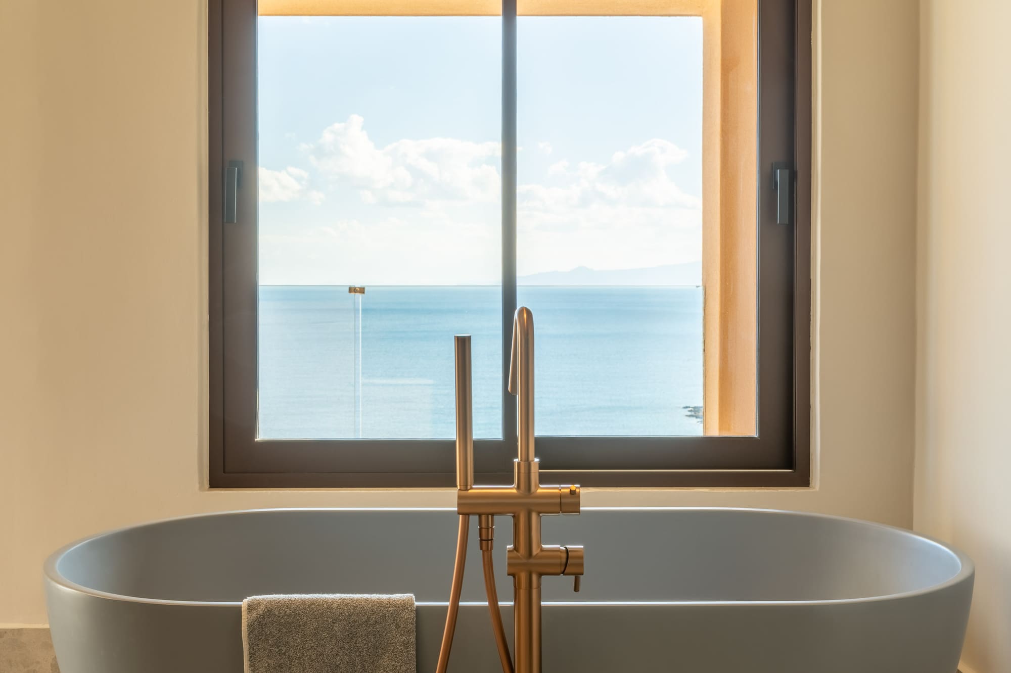 a bathtub with a window overlooking the ocean