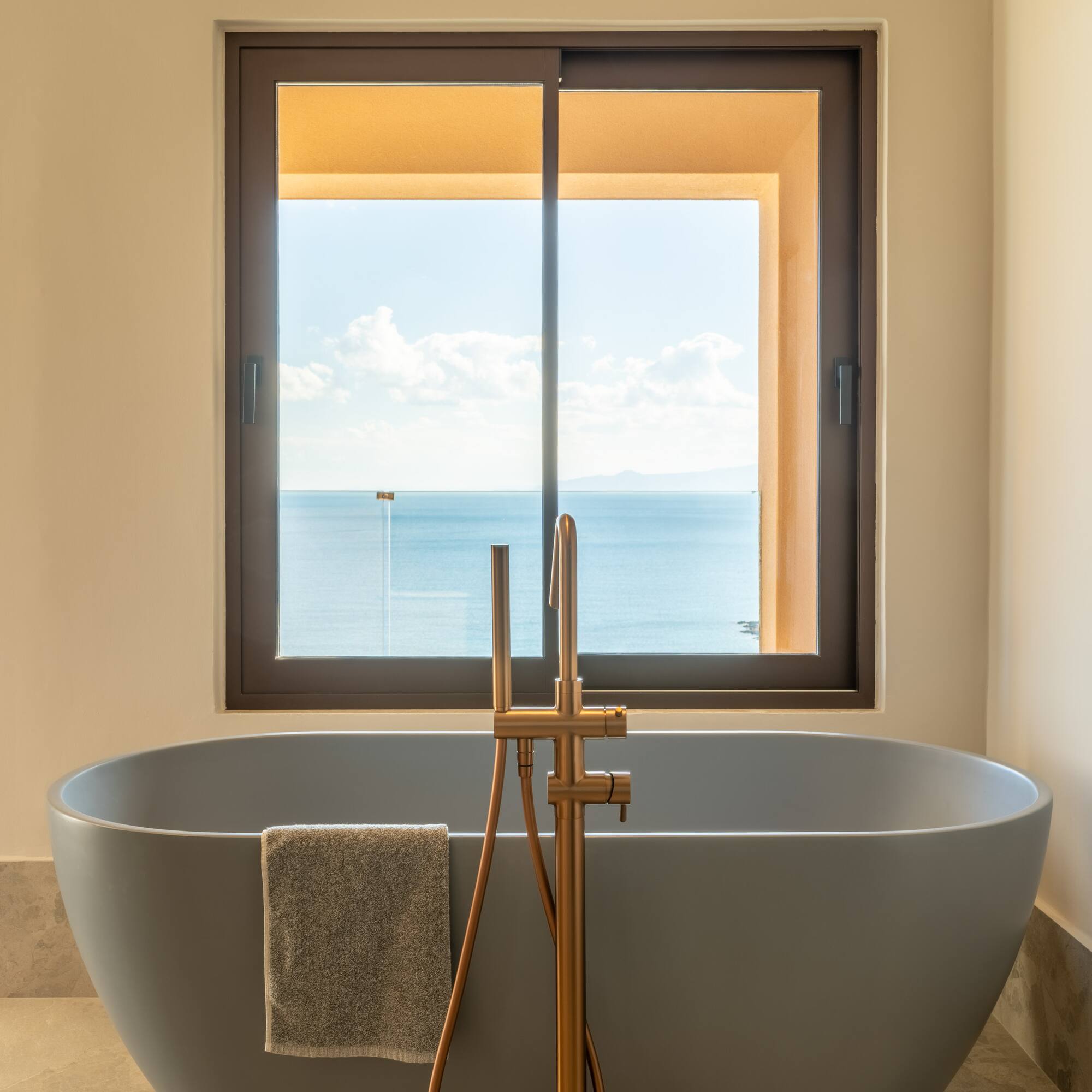 a bathtub with a window overlooking the ocean