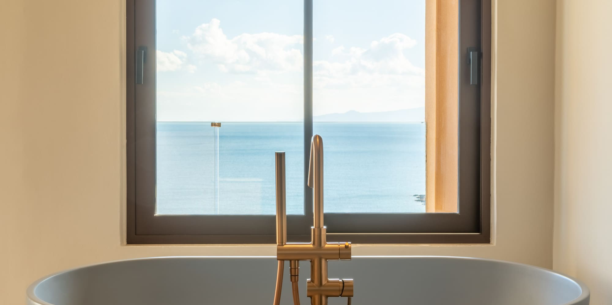 a bathtub with a window overlooking the ocean