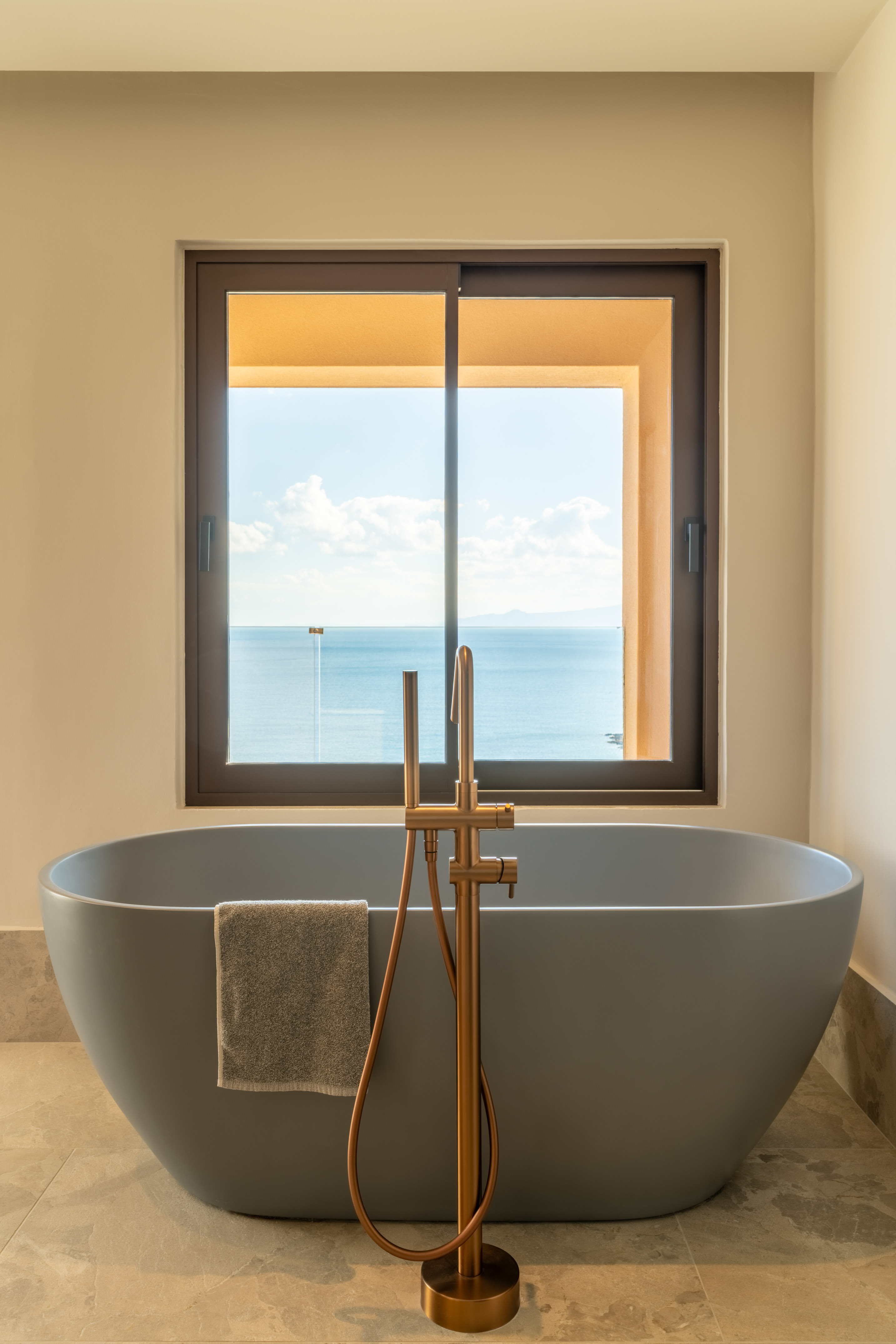a bathtub with a window overlooking the ocean