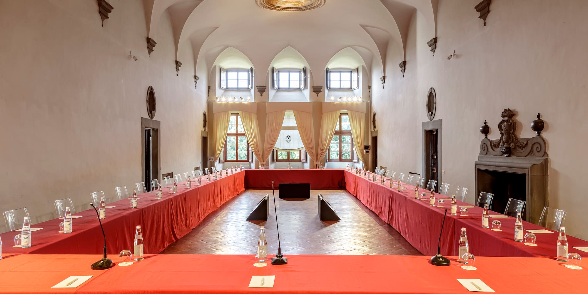 a room with red tablecloths and chairs