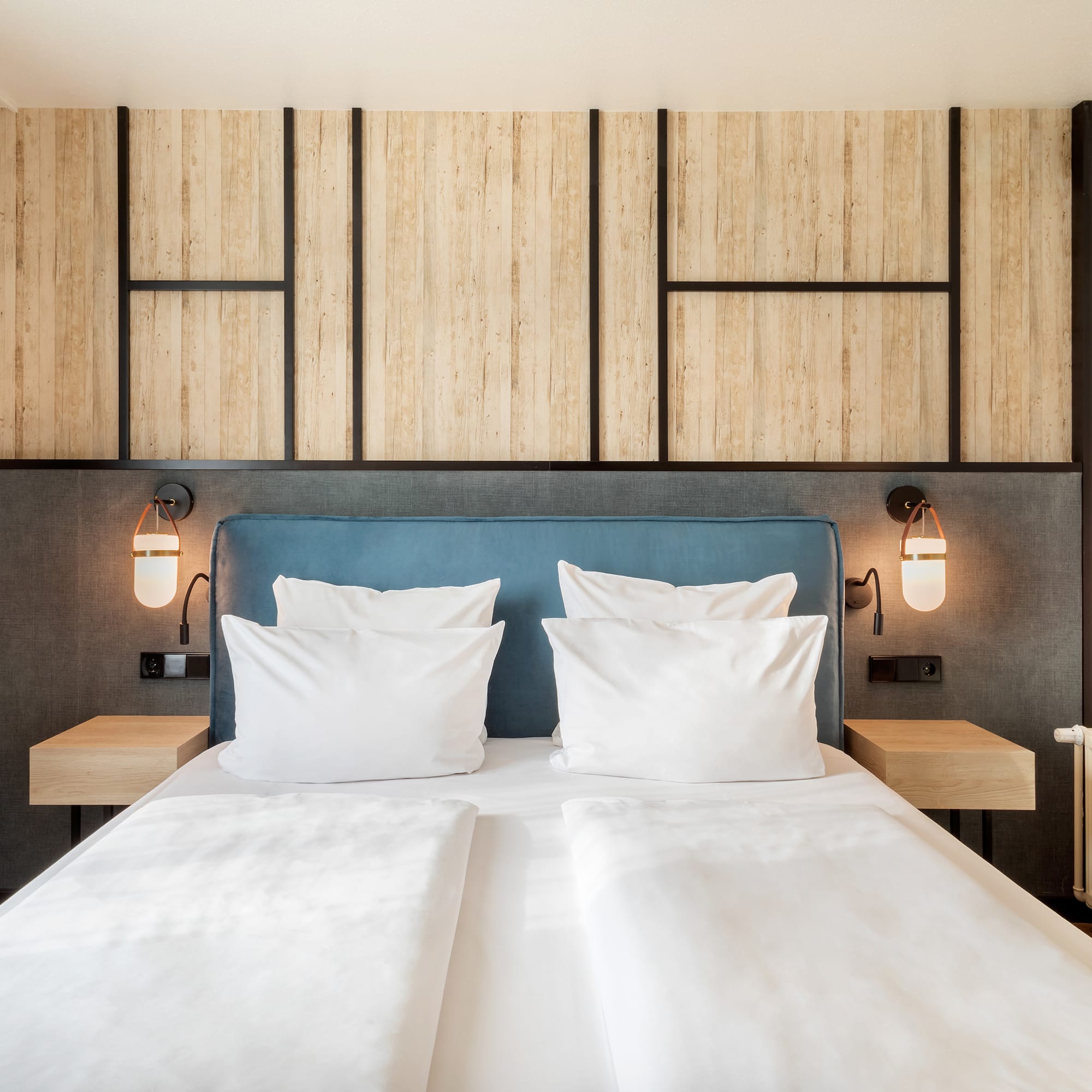 a bed with white pillows and a blue headboard