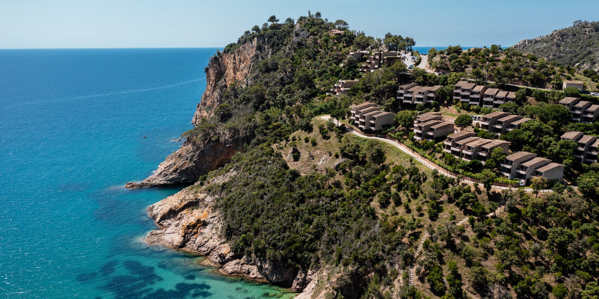 a group of buildings on a hill next to a body of water