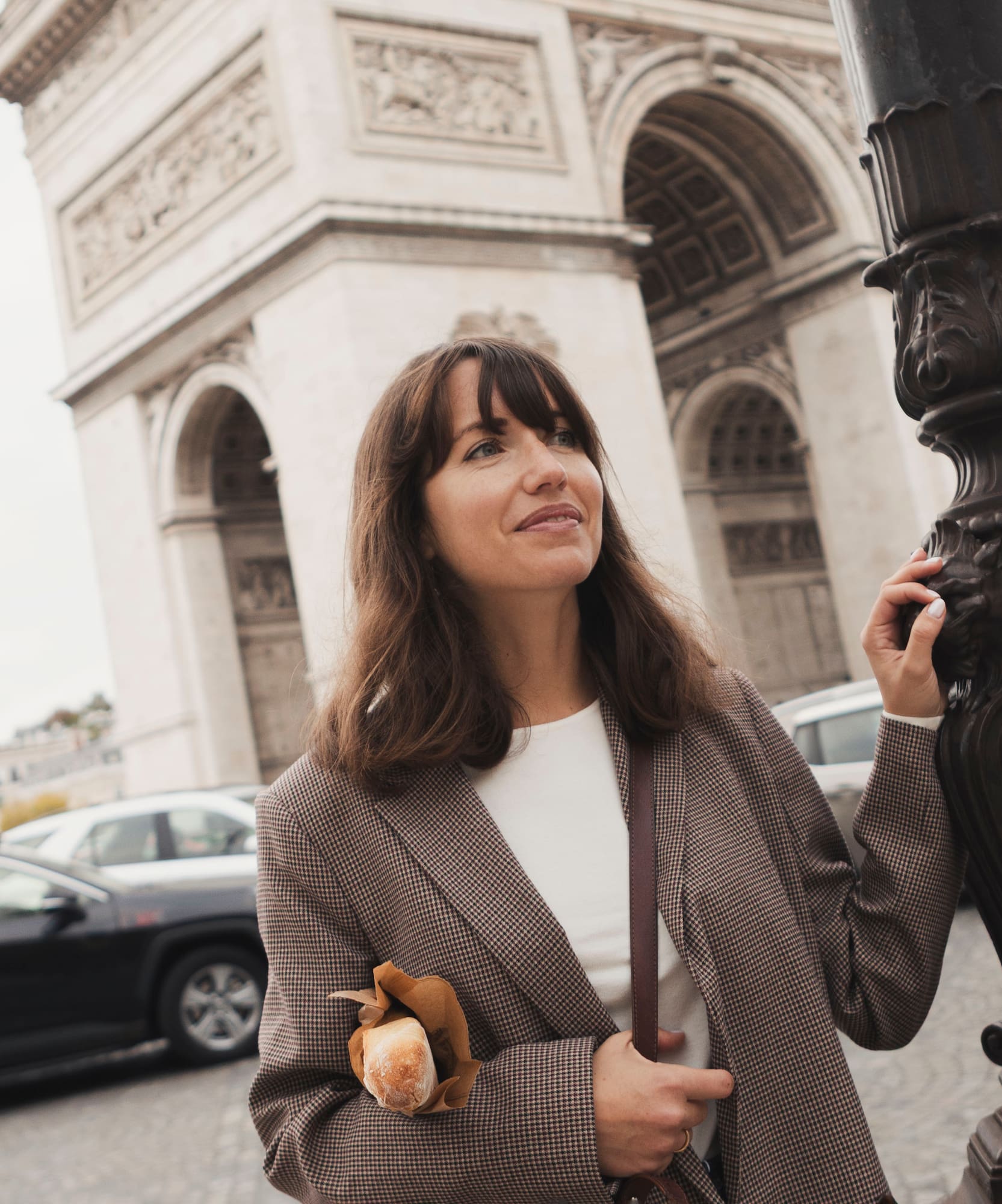 a woman standing next to a lamp post