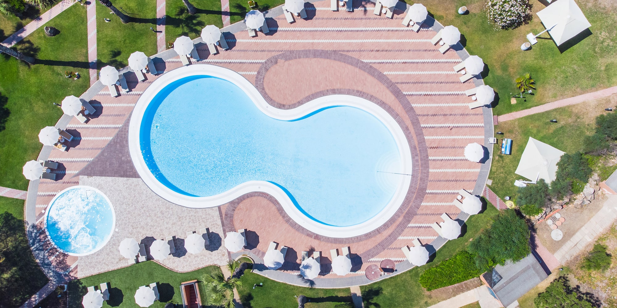 a pool with umbrellas and grass