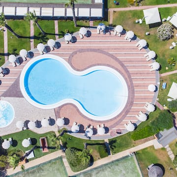 a pool with umbrellas and grass