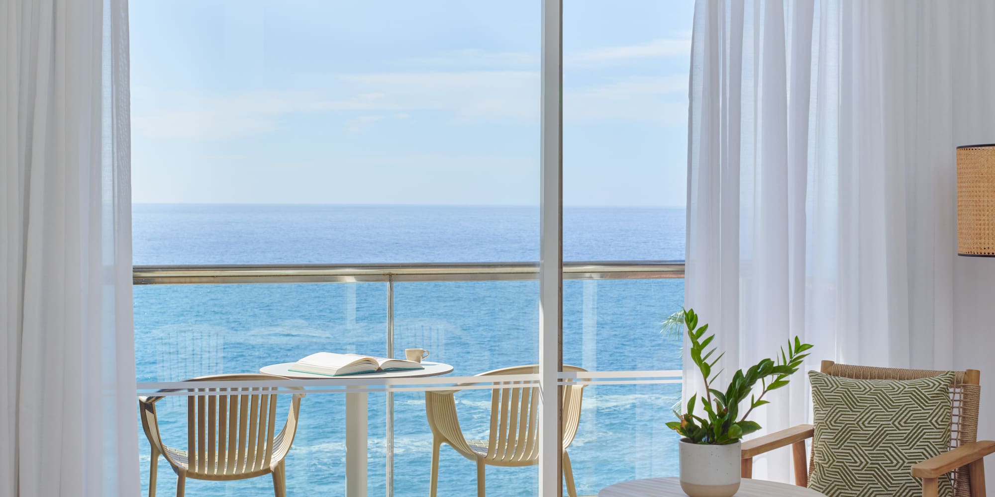a balcony with a table and chairs and a plant