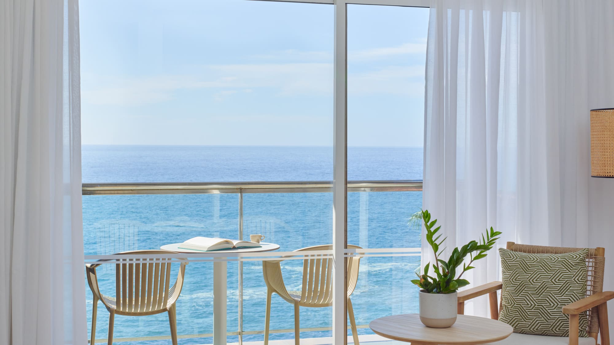 a balcony with a table and chairs and a plant