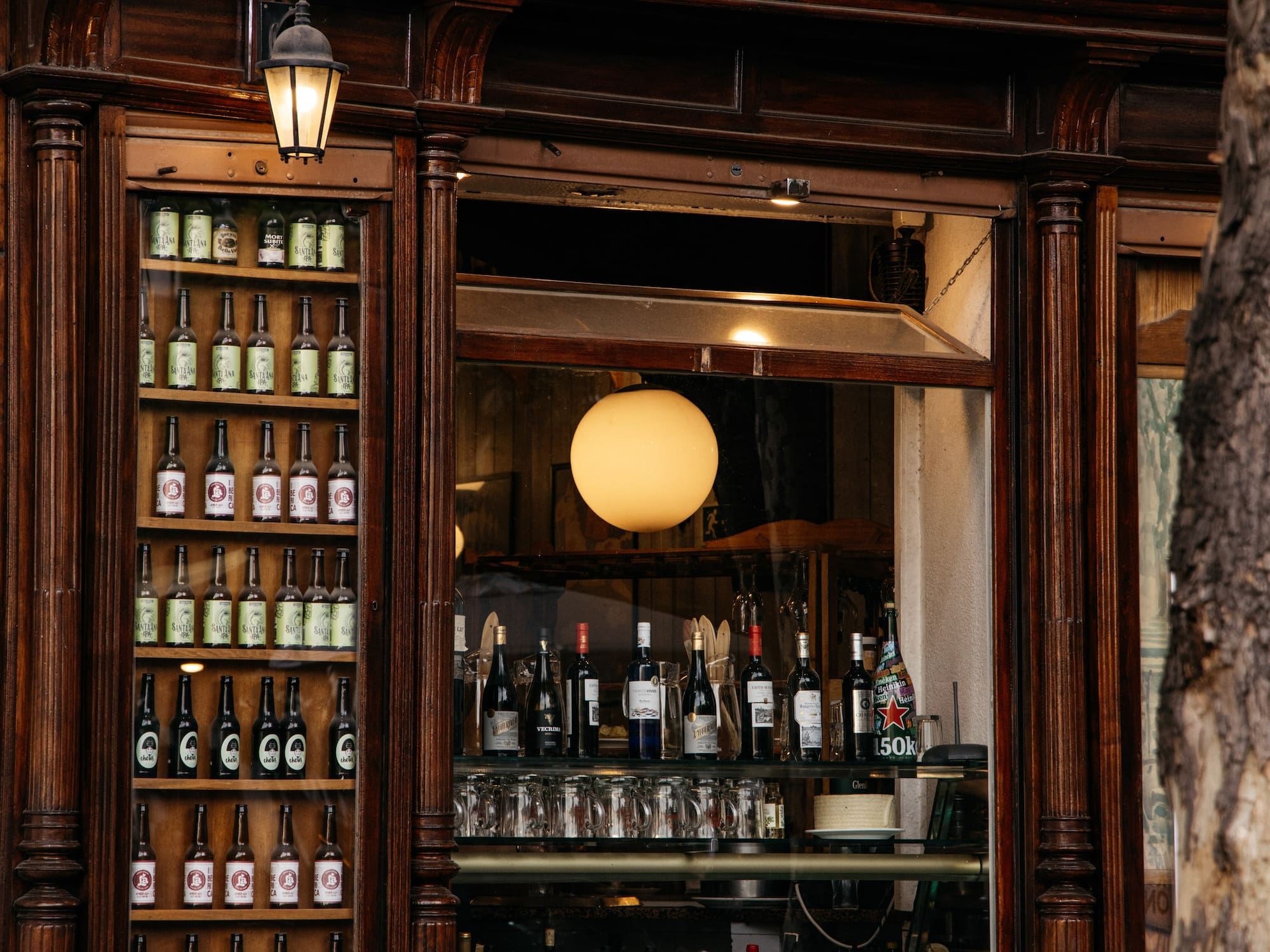 A shop front featuring a sign and shelves filled with bottles of alcohol.